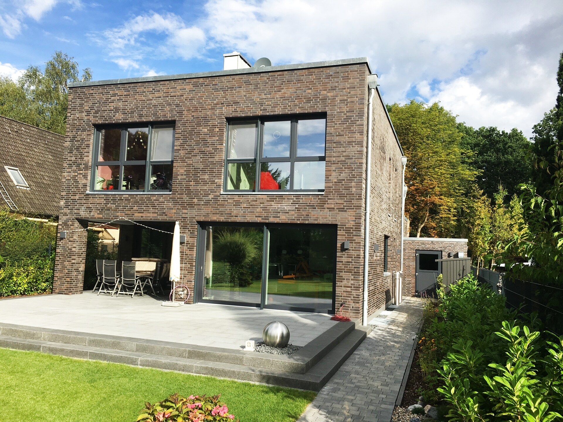 Einfamilienhaus Tornesch – Gartenseite mit Terrasse und Schiebefenstern